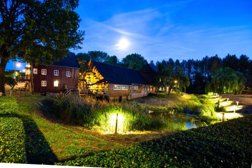 a barn at night with lights in the grass at Pullman Eindhoven Cocagne in Eindhoven