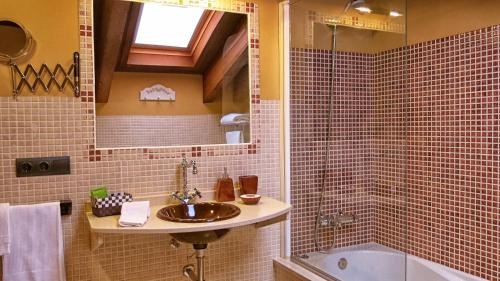 a bathroom with a sink and a bath tub at Hotel Valle del Silencio in San Esteban de Valdueza