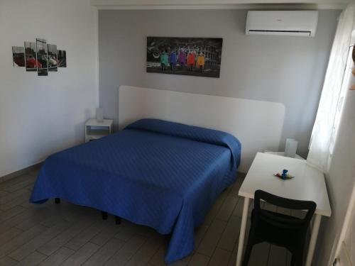 a small bedroom with a blue bed and a table at B&B dal Gallo in Battipaglia