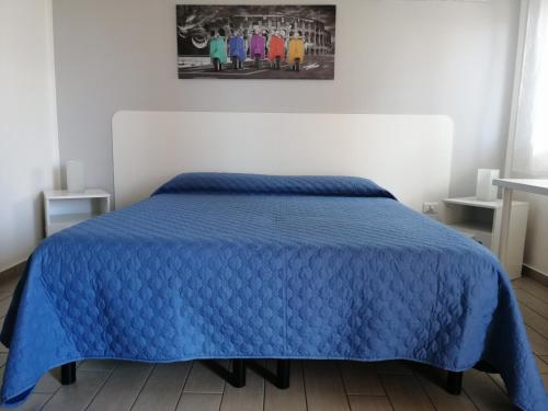 a bed with a blue comforter in a bedroom at B&B dal Gallo in Battipaglia