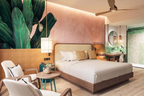 a bedroom with a bed and a living room at Tropical Deluxe Princess - All Inclusive in Punta Cana