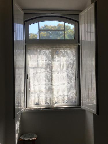 a window with a curtain in a room at Casa das Netas in Lagos