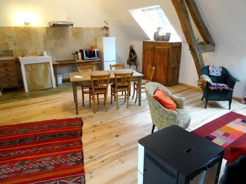 une cuisine et une salle à manger avec une table et des chaises dans l'établissement L'escalier des rêves, à Saint-Sauveur-en-Puisaye