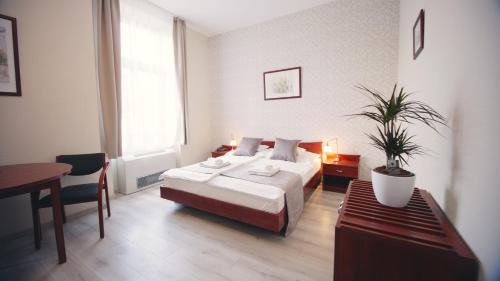 sypialnia z łóżkiem i stołem z doniczką w obiekcie Aqua Villa Eger w Egerze