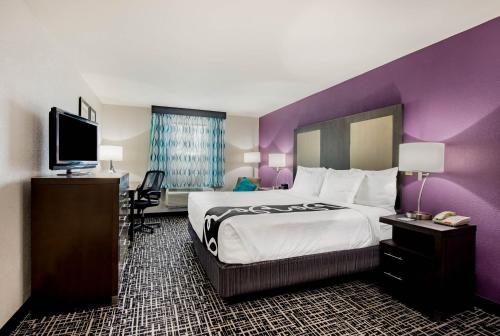 a hotel room with a large bed and a flat screen tv at La Quinta Inn by Wyndham West Long Branch NJ Shore Area in West Long Branch