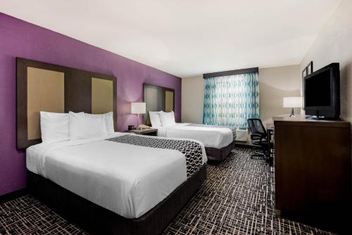 a hotel room with two beds and a flat screen tv at La Quinta Inn by Wyndham West Long Branch NJ Shore Area in West Long Branch