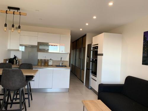 une cuisine et un salon avec un canapé et une table dans l'établissement T2 Hyeres La Bergerie vue mer 50 M de la plage, à Hyères