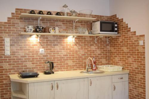 a kitchen with a sink and a brick wall at Prywatne Apartamenty in Kazimierz Dolny
