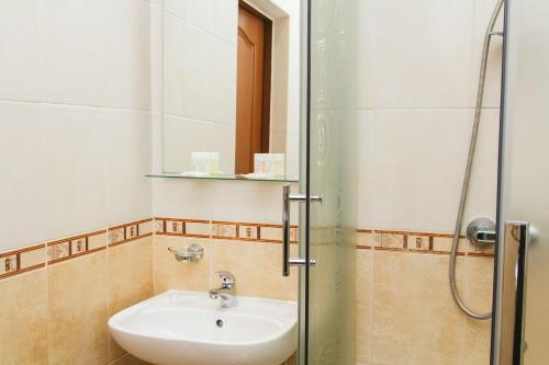 a bathroom with a sink and a shower at Korona Hotel in Boryspilʼ