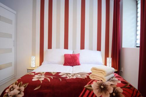 a bedroom with a bed with red and white stripes at Prywatne Apartamenty in Kazimierz Dolny