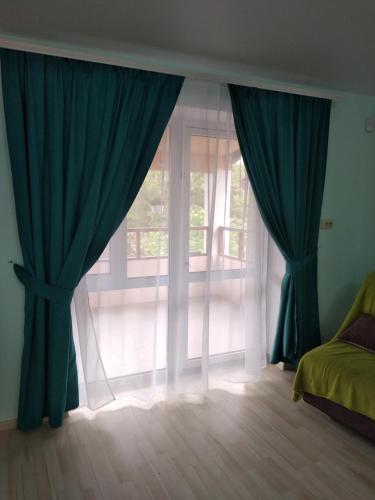 a window with blue curtains in a room at Вапнярка, Одесская область, жилье у моря in Vapnyarka