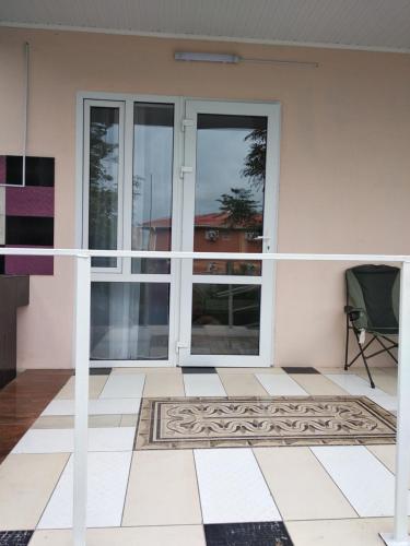a house with sliding glass doors and a chair at Вапнярка, Одесская область, жилье у моря in Vapnyarka