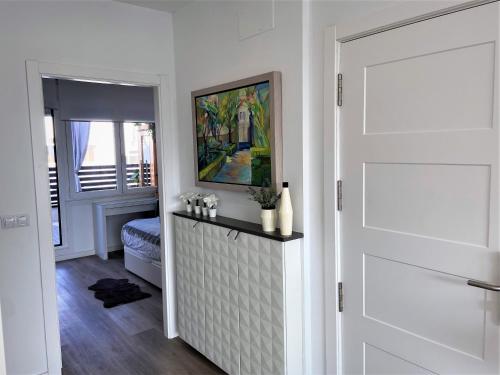 un pasillo blanco con una puerta y una pintura en 4 Apartamentos de Autor, en Lugo