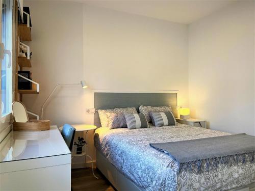 Un dormitorio con una cama, un escritorio y una lámpara. en 4 Apartamentos de Autor, en Lugo