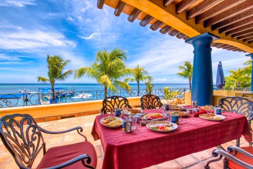 a table on a balcony with a view of the ocean at Caribe Tesoro in West Bay