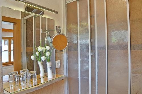 a bathroom with a counter with a mirror and flowers at Haus Adlerkanzel in Scharnitz