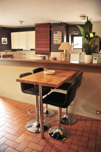 une cuisine avec une table en bois et des chaises noires dans l'établissement Logement au calme F2, à Metz