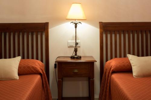 
a hotel room with two beds and a lamp at Apartamentos Plaza Cavana 5 in Nerja
