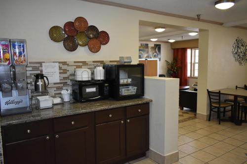 a kitchen with a counter top with a microwave at Super 8 by Wyndham Maumee Perrysburg Toledo Area in Maumee