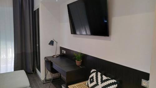 a room with a desk and a television on a wall at Mendez Nuñez Alicante in Alicante