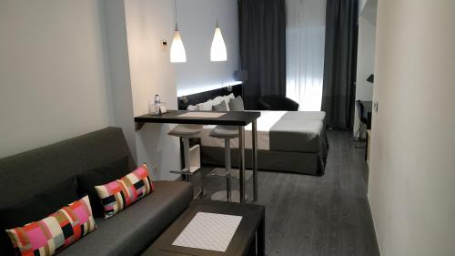 Habitación con cama, mesa y sofá en Mendez Nuñez Alicante, en Alicante