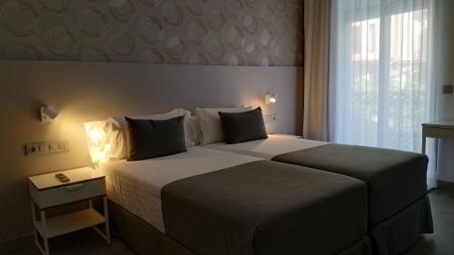 a hotel room with a large bed and a window at Mendez Nuñez Alicante in Alicante