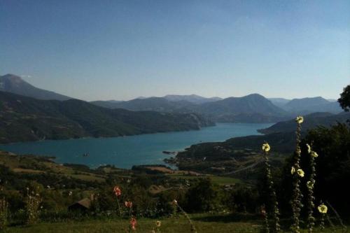 a view of a lake with mountains in the background at Belle maison Vue imprenable lac de Serre-Ponçon in Prunières