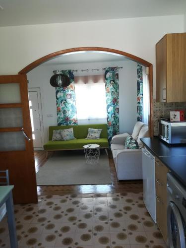 a living room with a green couch in a kitchen at O Nosso Cantinho in Louriçal