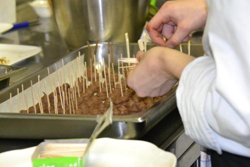 a person preparing food in a tray in a kitchen at Boutique Hotel de Rozenhof in Heilig Landstichting
