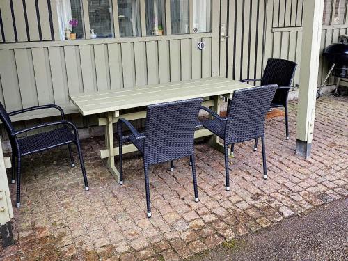 阿靈厄的住宿－7 person holiday home in Allinge，砖砌庭院里的野餐桌和椅子