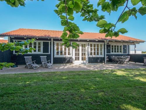 a house with chairs in front of a yard at 8 person holiday home in Aabenraa-By Traum in Aabenraa