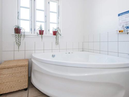 een badkamer met een wit bad en ramen bij Holiday Home Sandskærvej II in Aabenraa