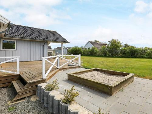 a backyard with a sandbox and a wooden deck at 8 person holiday home in Lemvig in Lemvig
