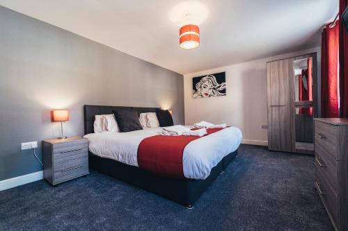 a bedroom with a large bed with a red blanket at The Stay Company, Mill Street in Derby