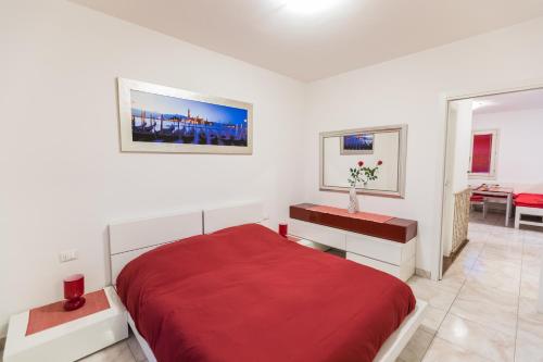 Habitación blanca con cama roja y escritorio. en Mugello1 - Affitti Brevi Italia, en Borgo San Lorenzo