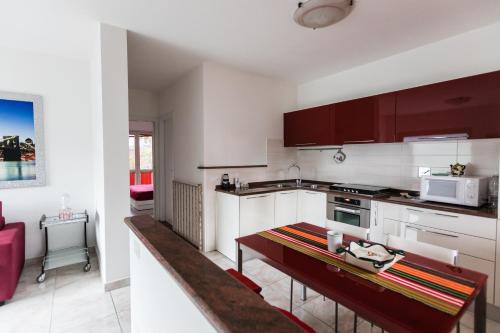a kitchen with white cabinets and a table in it at Mugello1 - Affitti Brevi Italia in Borgo San Lorenzo