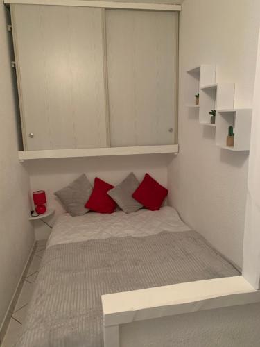 a small bedroom with a bed with red pillows at Cannes center in Cannes