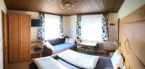 フィルツモースにあるハウス ヴァルドラストのベッド、デスク、窓が備わる小さな客室です。