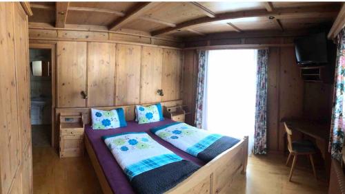 a bedroom with a large bed in a wooden room at Haus Waldrast in Filzmoos