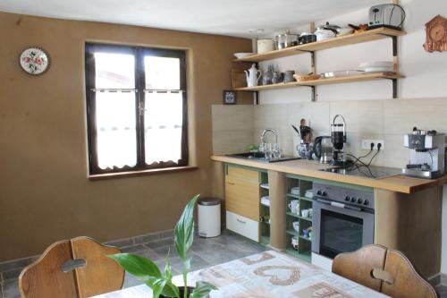 a kitchen with a counter and a table with chairs at Feriengut zum Trinkstorch in Leinsweiler