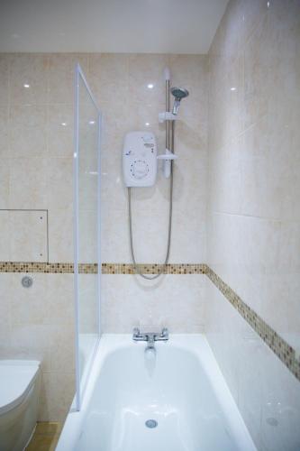 a bathroom with a shower and a bath tub at Velvet 1-bedroom apartment, Clockhouse, Hoddesdon in Hoddesdon