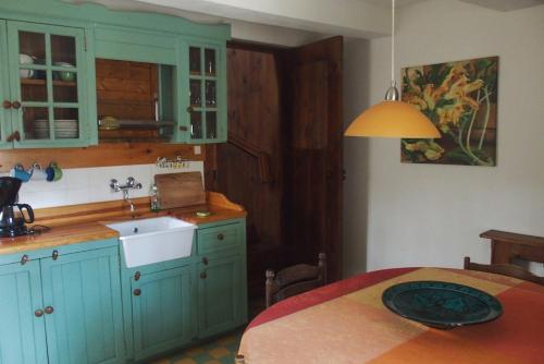 a kitchen with blue cabinets and a sink at Gite Les genêts, baronnies provençales in Montjay