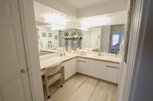 a bathroom with two sinks and a large mirror at Sunset Penthouse Condo in Branson
