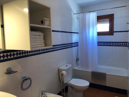 y baño con aseo, bañera y lavamanos. en Apartamentos Rurales Poqueira en Capileira