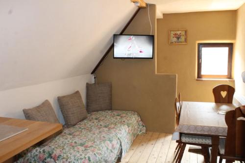 Habitación con cama y TV en la pared. en Feriengut zum Trinkstorch, en Leinsweiler