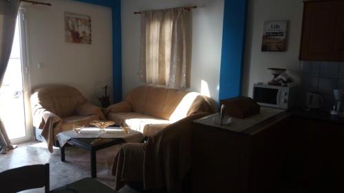 uma sala de estar com um sofá e uma mesa em John Galouzis Studios em Kalymnos