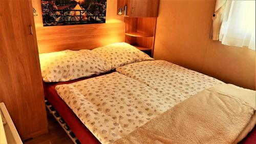 ein kleines Schlafzimmer mit einem Bett in einem Zimmer in der Unterkunft Holiday home Rozika in Slovenj Gradec