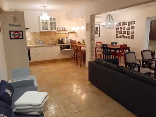 a living room and kitchen with a couch and a table at Naomi's in Rosh Pinna