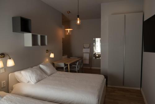 a hotel room with two beds and a table and a table at SMILE&LOVE REPUBLIC ZAGREB CENTER in Zagreb