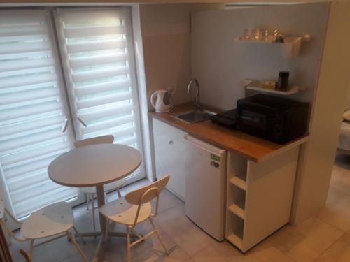 a small kitchen with a table and a small table and chairs at Sol De Sopot in Sopot